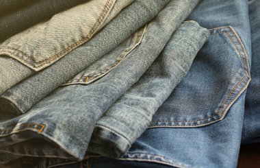 Soyunma odasında bir sürü kot pantolon var. Dolapta pantolon pantolonu var. Satın alma, satma, alışveriş ve modern kıyafetler kavramı