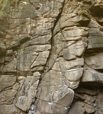 Hafif kaba doğal kaya arkaplanı. Maden kayalıkları ön yüzeye çıkıyor. Büyük bir kireçtaşı yığını. Ağır grunge hasarlı granit blok dokusu. Tasarım için antik ortaçağ taşlı cephesini kır