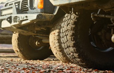 Çamur yolu olan bir kırsal alanda tekerlek yakın çekim. Off-road 4x4 SUV otomobil çamurlu yol alanında sürdükten sonra ditry body ile