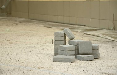 Dışarıdaki yığının içinde gri kaldırım levhaları var. Mozaik 'ten Paving Levhaları için malzeme. Çakıl taşı kurulum süreci
