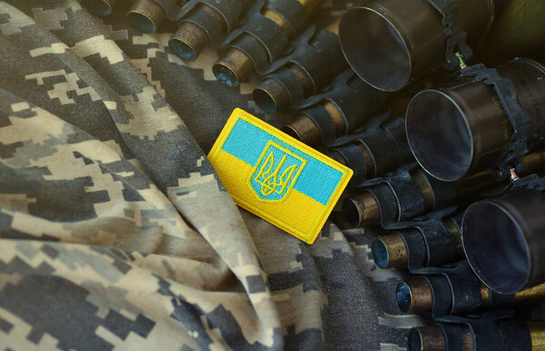 Украинский символ на пулемётном поясе лежит на украинском пиксельном военном камуфляже вблизи