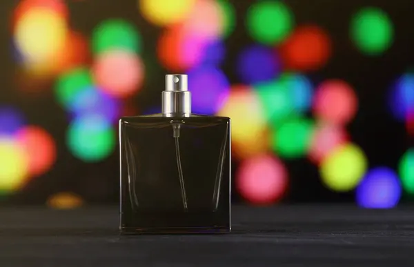 Women fragrance perfume bottle on dark festive background close up. Unnamed blank sprayer bottle of perfume for women