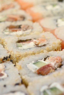 Bir sürü suşi Close-Up farklı dolguları yalanla ahşap yüzeyde alır. Bir kopya alanı ile pişmiş klasik Japon gıda makro çekim.