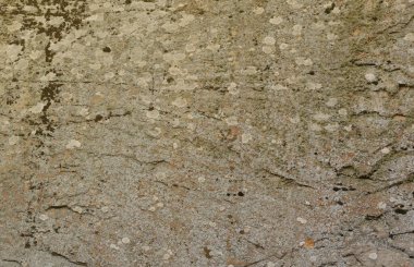 Closeup of the rough stone texture of a big rock surface for natural background concepts. Closeup dirty natural stone background texture in warm tones