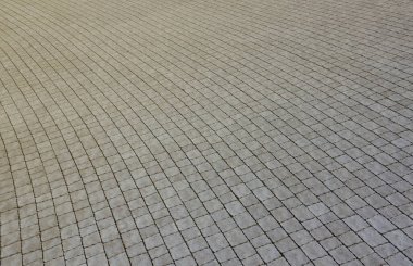 Yaya kaldırımındaki gri asfalt levhalar. Sert kaldırım taşı desenli, kare şeklinde birçok taş var.