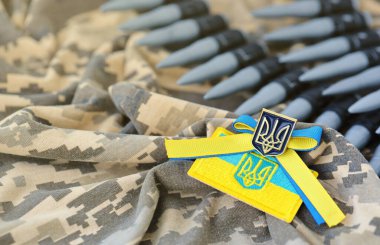 Ukrayna sembolü ve bir Ukraynalı askerin kamuflaj üniformasında makineli tüfek kemeri. Ukrayna 'daki savaş kavramı, vatanseverlik ve ülkenizi Rus işgalcilerden korumak.