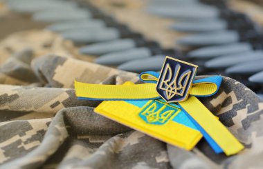 Ukrayna sembolü ve bir Ukraynalı askerin kamuflaj üniformasında makineli tüfek kemeri. Ukrayna 'daki savaş kavramı, vatanseverlik ve ülkenizi Rus işgalcilerden korumak.