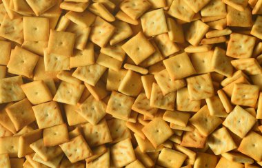 Küçük kurabiye çok kare şeklinde. Sarı tuzlu kraker bir model. Arka plan görüntüsü ile tuzlu pasta