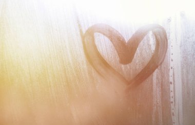 Yağmurlu havalarda misted camına bir parmak tarafından çizilmiş bir kalp şeklinde çizim