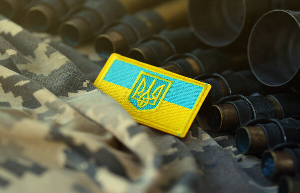 Украинский символ на пулемётном поясе лежит на украинском пиксельном военном камуфляже вблизи