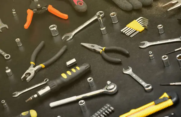 Handyman tool kit on black wooden table. Many wrenches and screwdrivers, pilers and other tools for any types of repair or construction works. Repairman tools set