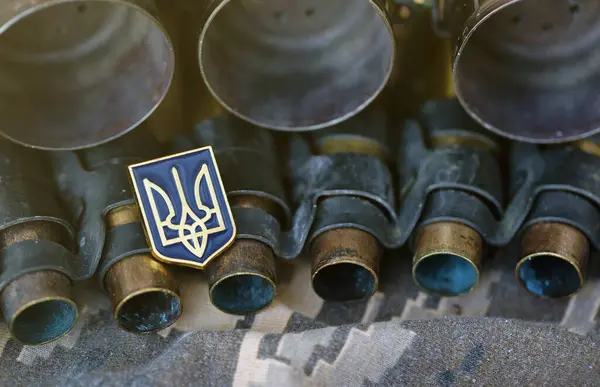 Ukrainian symbol on machine gun belt lies on ukrainian pixeled military camouflage close up