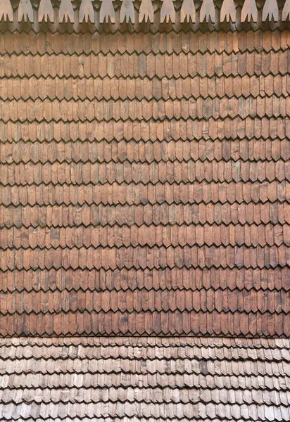 Gray wooden roof tiles background texture. A close up of old gray roof covered with wooden tiles or shingles