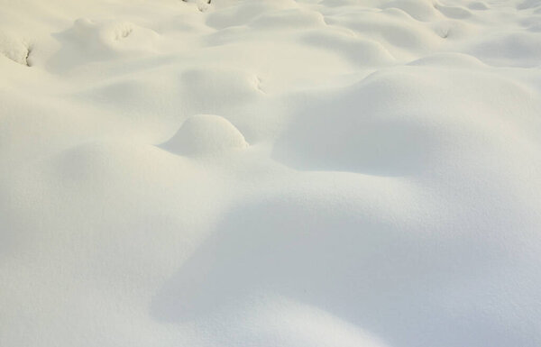 Fragment of the road, covered with a thick layer of snow. The texture of the glistening snow cover