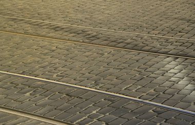 Metal tramvay rayları dışarı pürüzsüz bir kaldırım taşı atılmıştır yolun ortasında