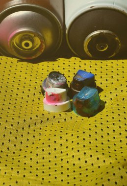 Kullanılan sprey boya püskürtme için çeşitli kapaklar polyester kumaştan yapılmış bir basketbol oyuncusu spor forması yalan. Gençlik sokak sanatı, aktif spor ve hareketli yaşam tarzı kavramı