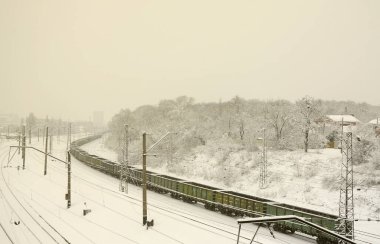 Yük arabalar uzun bir tren tren yolu hareket ediyor. Demiryolu manzara kış kar yağışı sonra