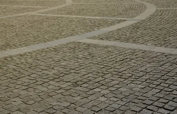 Parlak güneş ışığı altında kare şeklin birçok küçük taşları kaldırım levha (kaldırım taşları) doku