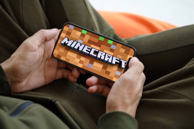 Minecraft mobil iOS oyunu iPhone 15 akıllı telefon ekranında, oyun sırasında erkeklerin elinde. Taşınabilir aygıtta mobil oyun ve eğlence