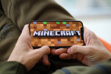 Minecraft mobil iOS oyunu iPhone 15 akıllı telefon ekranında, oyun sırasında erkeklerin elinde. Taşınabilir aygıtta mobil oyun ve eğlence