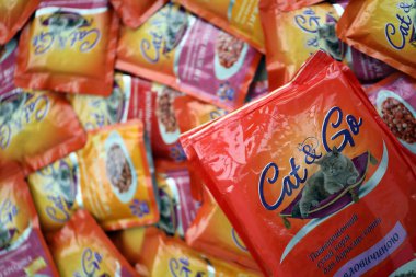 KYIV, UKRAINE - 4 Mayıs 2023: Turuncu paketleri olan kedi ve kedi maması