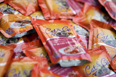 KYIV, UKRAINE - 4 Mayıs 2023: Turuncu paketleri olan kedi ve kedi maması