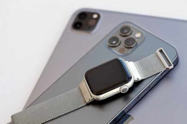 stock image KYIV, UKRAINE - 4 MAY, 2023: Apple brand devices iphone, ipad with apple watch lies on macbook body close up