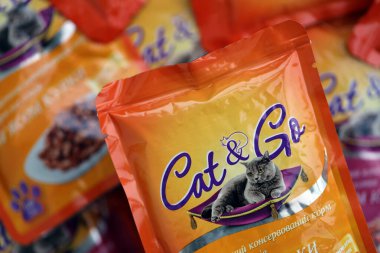 KYIV, UKRAINE - 4 Mayıs 2023: Turuncu paketleri olan kedi ve kedi maması