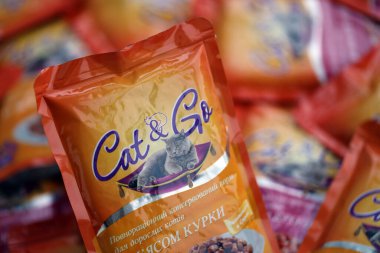 KYIV, UKRAINE - 4 Mayıs 2023: Turuncu paketleri olan kedi ve kedi maması