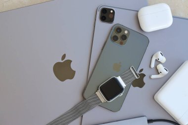 KYIV, UKRAINE - 4 MAY, 2023: Apple brand devices iphone, ipad and airpods with apple watch lies on macbook body close up clipart