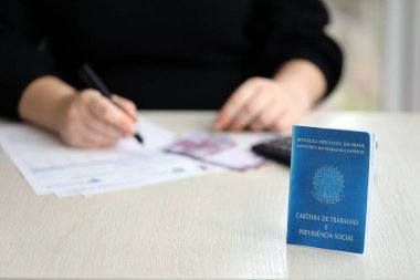 Brezilya iş kartı ve sosyal güvenlik mavi kitabı muhasebeci ya da patron masasında yatıyor.