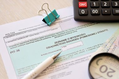 Kazanılan gelir ya da zarar miktarının beyanı, muhasebeci masasının üzerindeki PIT-36 vergi formları ve kalem ve zloti para faturalarının kapatılması