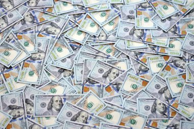 Çok büyük miktarlarda 100 dolarlık banknotlar kapanıyor. Düz tablonun üzerinde büyük miktarda Birleşik Devletler para birimi notu var.