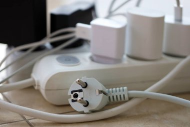 Aşırı yüklenmiş güç panoları. Beyaz zeminde farklı elektrik prizleri olan elektrik şeritleri. Risk tehlikesi kavramı elektrik akımını aşırı yükledi