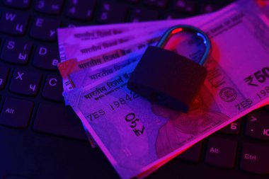 Kapalı asma kilit ve dizüstü bilgisayarda Hint rupileri var. Hindistan 'da güvenli online bankacılık veya online alışveriş kavramı