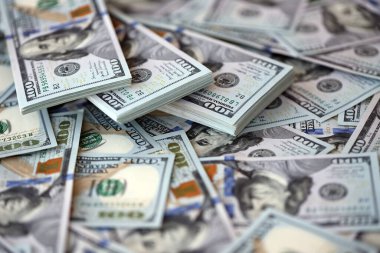 Çok büyük miktarlarda 100 dolarlık banknotlar kapanıyor. Düz tablonun üzerinde büyük miktarda Birleşik Devletler para birimi notu var.