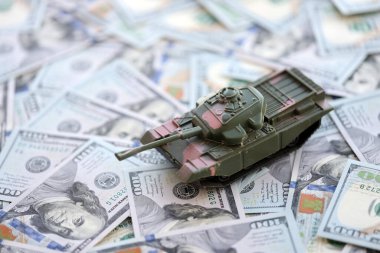 100 dolarlık banknotlardaki oyuncak tankları kapatın. Savaş maliyetleri, askeri harcamalar ve ekonomik kriz kavramı