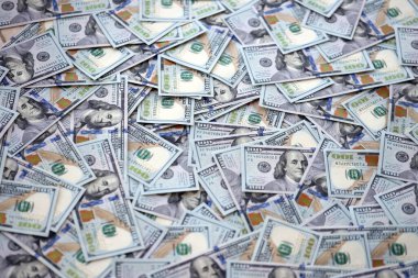 Çok büyük miktarlarda 100 dolarlık banknotlar kapanıyor. Düz tablonun üzerinde büyük miktarda Birleşik Devletler para birimi notu var.