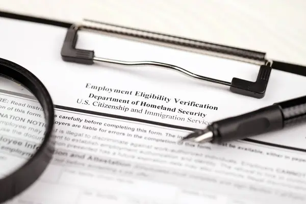 I-9 Employment Eligibility Verification blank form on A4 tablet lies on office table with pen and magnifying glass close up
