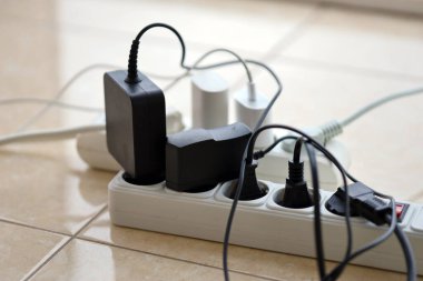 Aşırı yüklenmiş güç panoları. Beyaz zeminde farklı elektrik prizleri olan elektrik şeritleri. Risk tehlikesi kavramı elektrik akımını aşırı yükledi