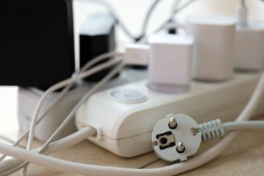 Aşırı yüklenmiş güç panoları. Beyaz zeminde farklı elektrik prizleri olan elektrik şeritleri. Risk tehlikesi kavramı elektrik akımını aşırı yükledi