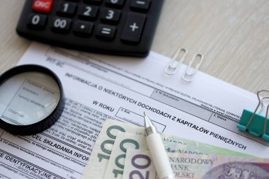 Parasal sermayeden elde edilen gelir hakkında bilgi, muhasebeci masasının üzerindeki PIT-8C formu. Kalem ve zloti paraları kapatılacak.