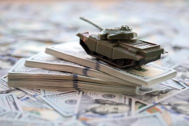 100 dolarlık banknotlardaki oyuncak tankları kapatın. Savaş maliyetleri, askeri harcamalar ve ekonomik kriz kavramı