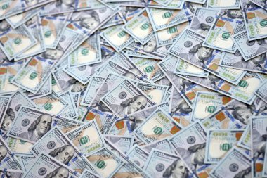 Çok büyük miktarlarda 100 dolarlık banknotlar kapanıyor. Düz tablonun üzerinde büyük miktarda Birleşik Devletler para birimi notu var.