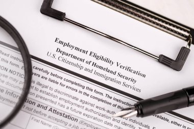 I-9 Employment Eligibility Verification blank form on A4 tablet lies on office table with pen and magnifying glass close up clipart