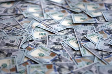 Çok büyük miktarlarda 100 dolarlık banknotlar kapanıyor. Düz tablonun üzerinde büyük miktarda Birleşik Devletler para birimi notu var.