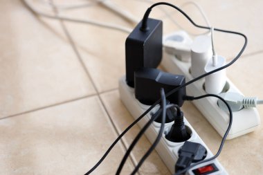 Aşırı yüklenmiş güç panoları. Beyaz zeminde farklı elektrik prizleri olan elektrik şeritleri. Risk tehlikesi kavramı elektrik akımını aşırı yükledi