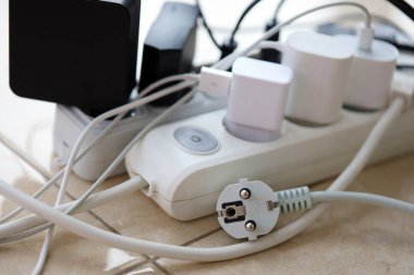 Aşırı yüklenmiş güç panoları. Beyaz zeminde farklı elektrik prizleri olan elektrik şeritleri. Risk tehlikesi kavramı elektrik akımını aşırı yükledi
