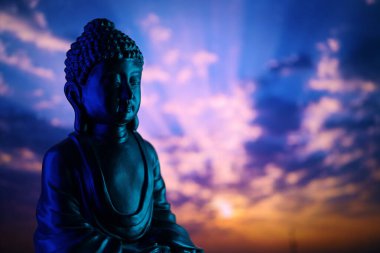 Buddha Purnima ve Vesak Günü konsepti, güzel ve renkli arka plana karşı yumuşak ışık saçan Buda heykeli. Meditasyon