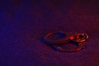 Polis arabasıyla gece karanlığın yüzeyinde kelepçeler kapalı. Yüksek kontrastlı görüntüler var.